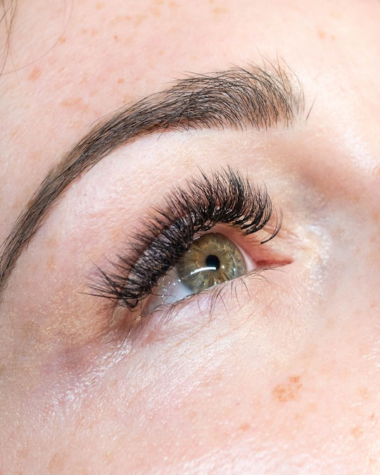 Close-up of lash extensions applied to natural lashes