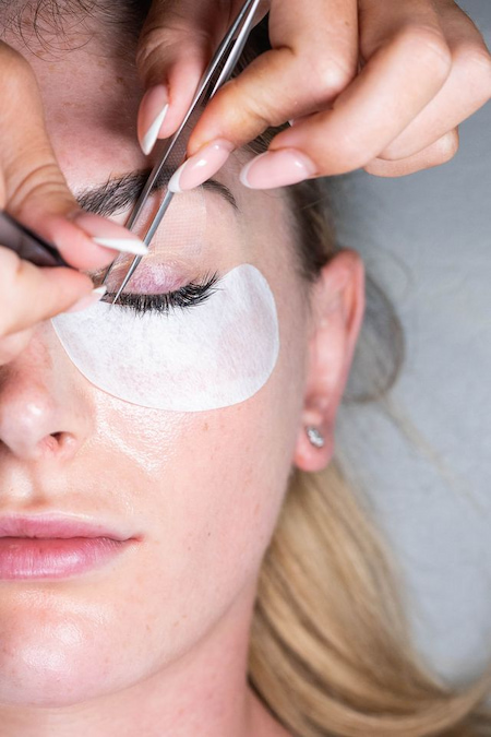 Fine lash extension being placed onto an isolated natural lash