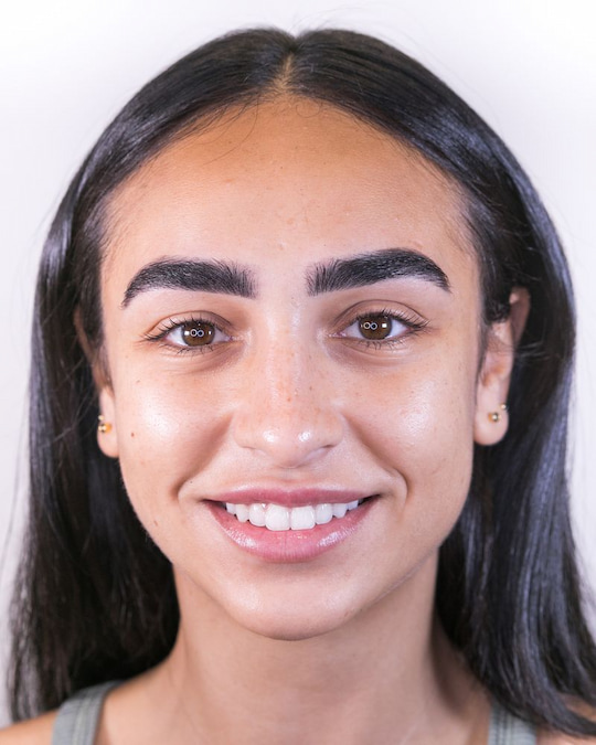 Client smiling with soft, healed brows that look natural
