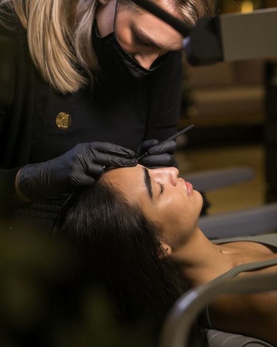 Brau artist working on a client's brows in the studio