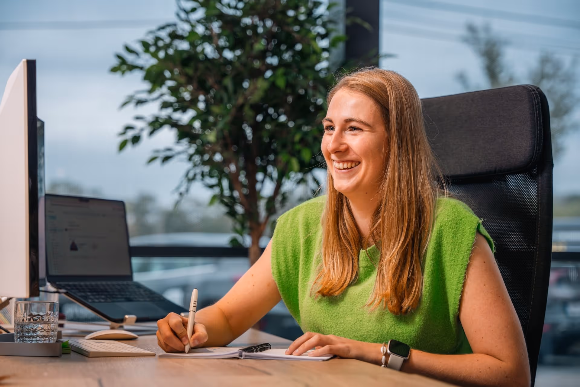 Eva heeft een balpen in de hand en noteert in een notitieboekje.