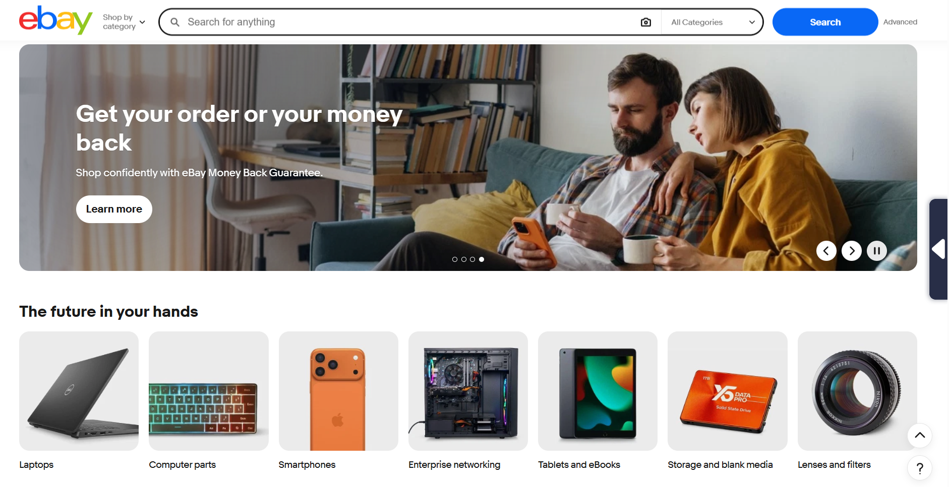 eBay homepage showing search bar, buyer protection banner, featured electronics categories including laptops and smartphones, plus navigation tools for browsing products across multiple categories.