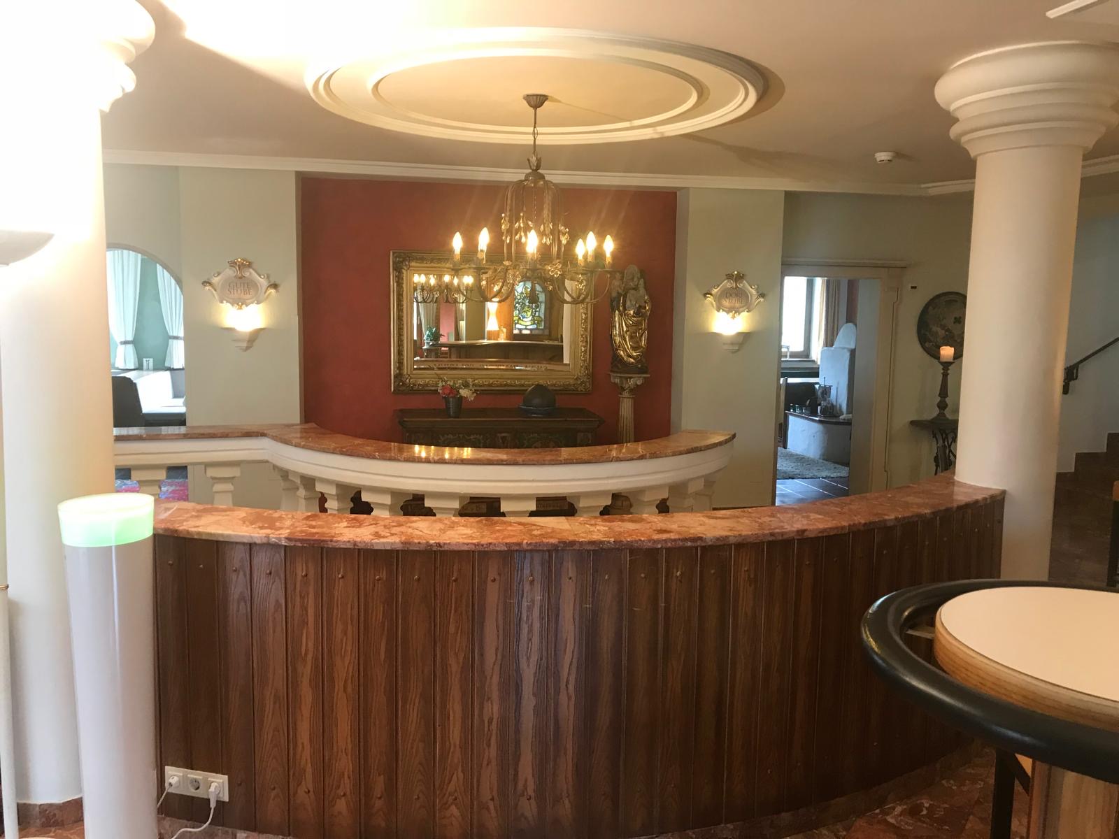 Elegante Rezeption des Malerbetrieb in Münster mit Kronleuchter und Holztresen