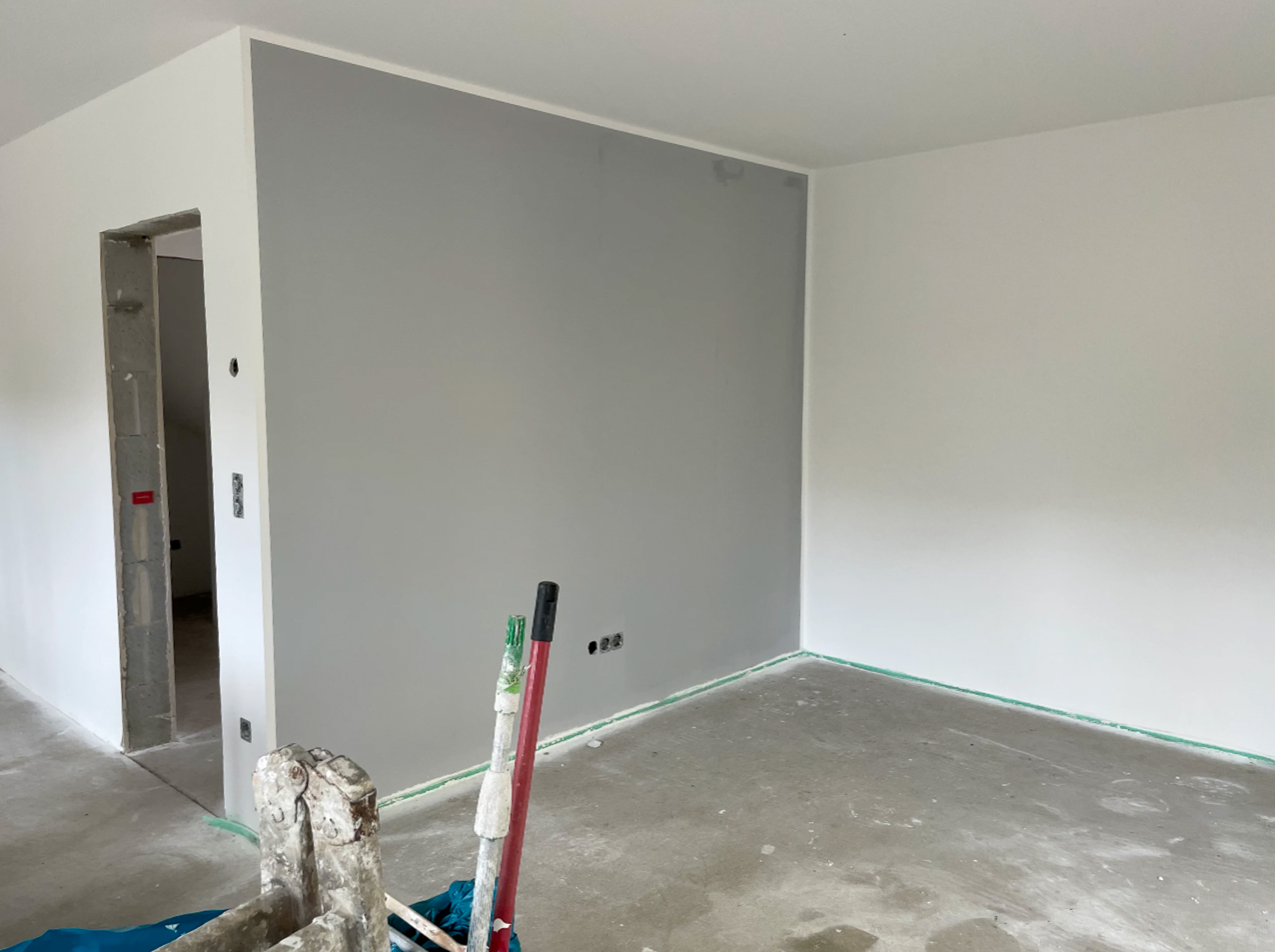 Malerbetrieb Münster bei Wandgestaltung mit grauer Akzentwand im Rohbau