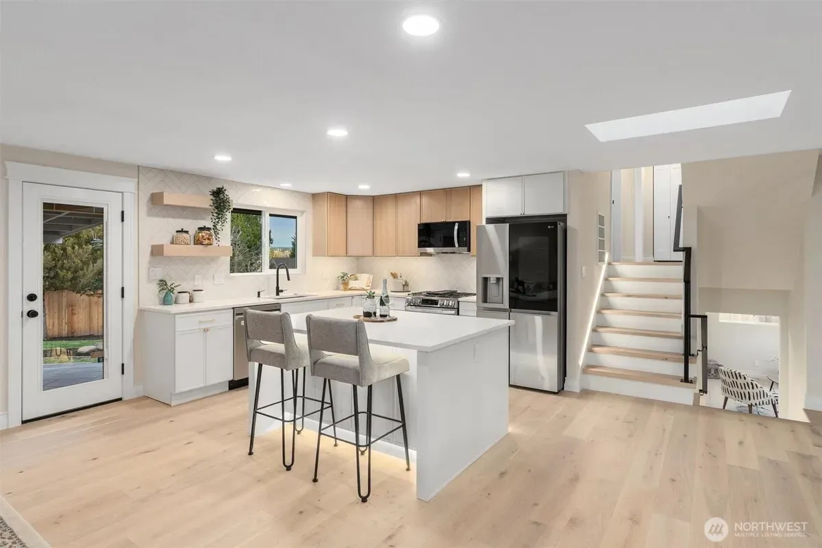 Spacious open-plan modern kitchen and dining area with hardwood floors