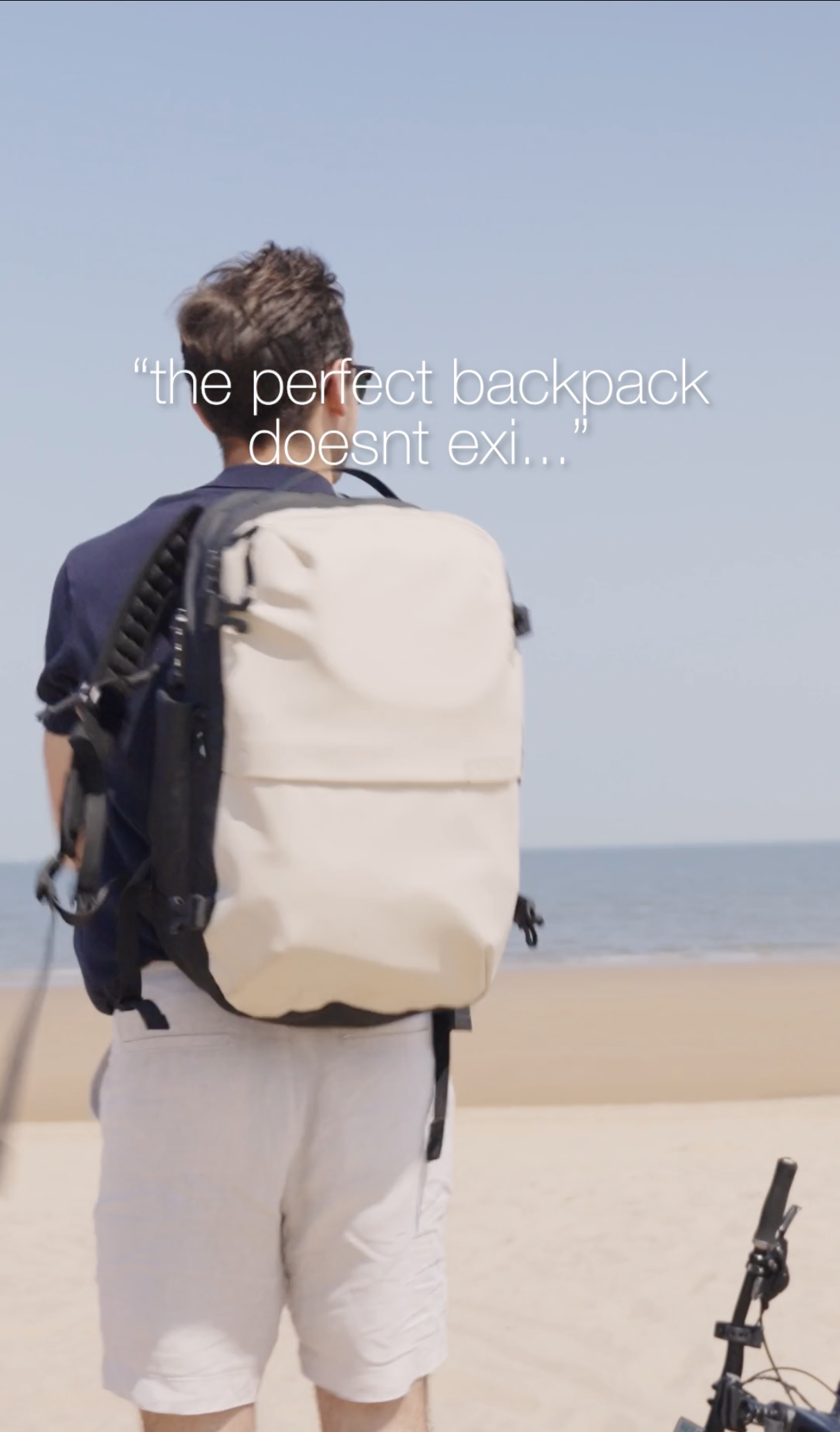 Young man walking on the beach with a backpack