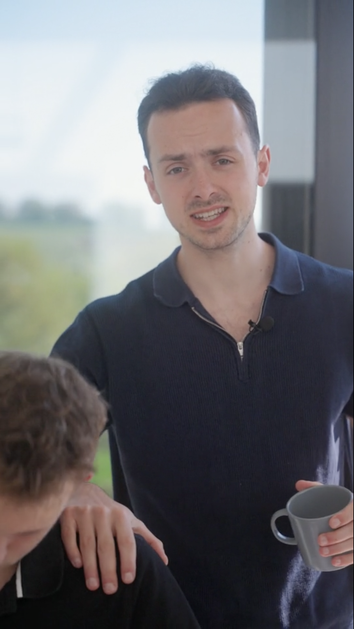 A young man tapping on the shoulder of a student