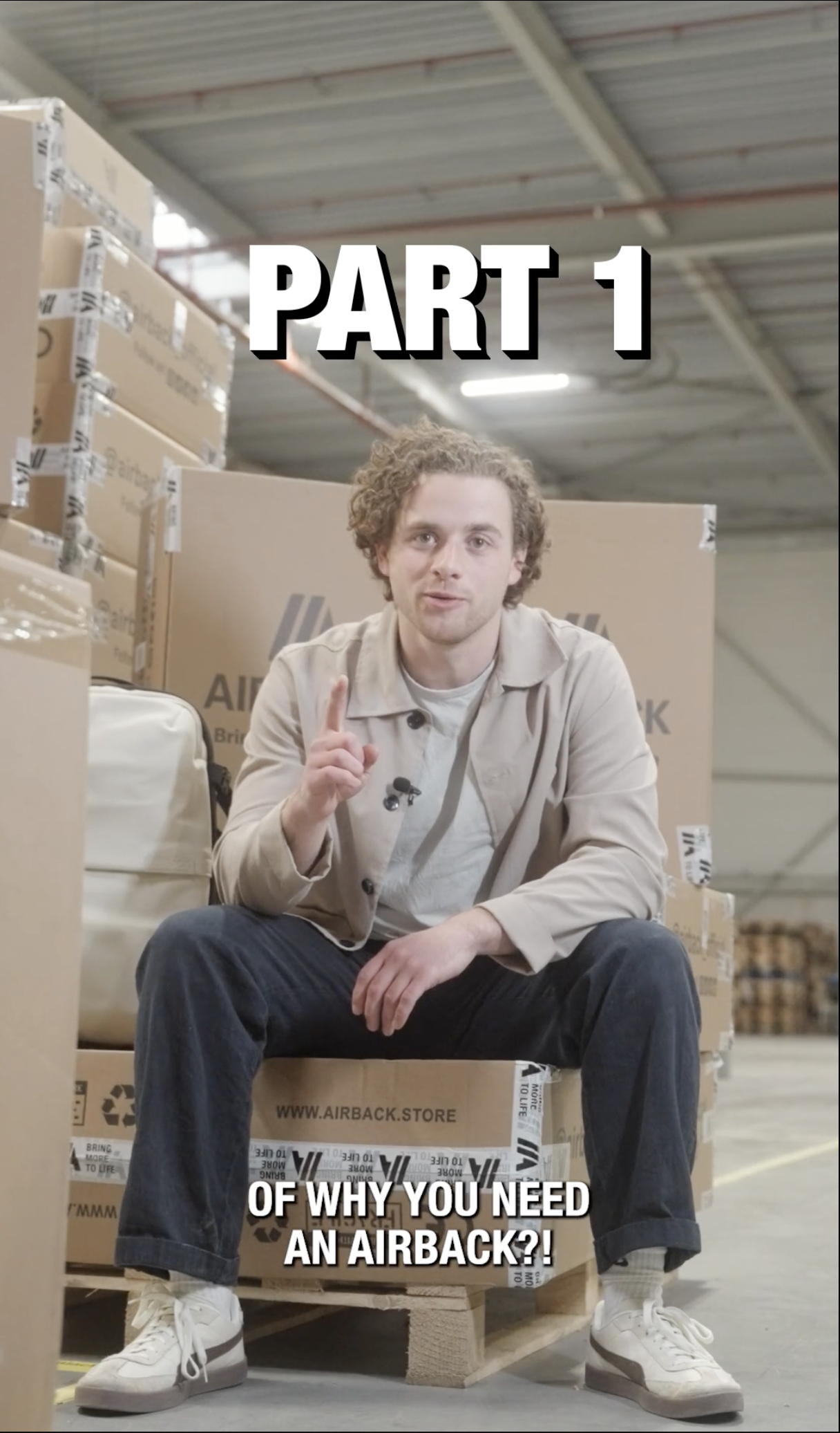 A young man sitting in front of boxes 