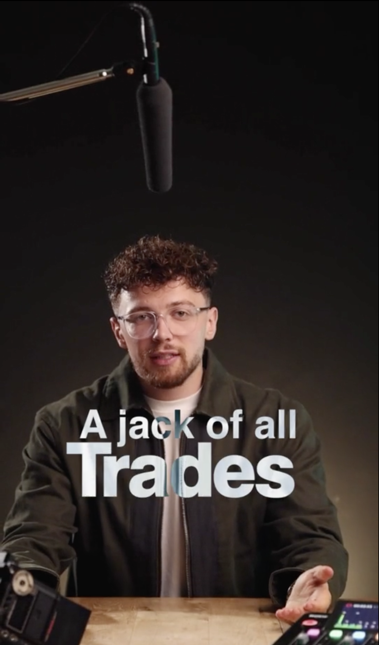 A young entrepreneur sitting at his desk with a microphone above