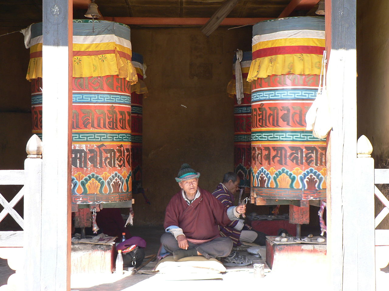 Elder turning a traditional prayer wheel, reflecting Guru App’s spiritual roots