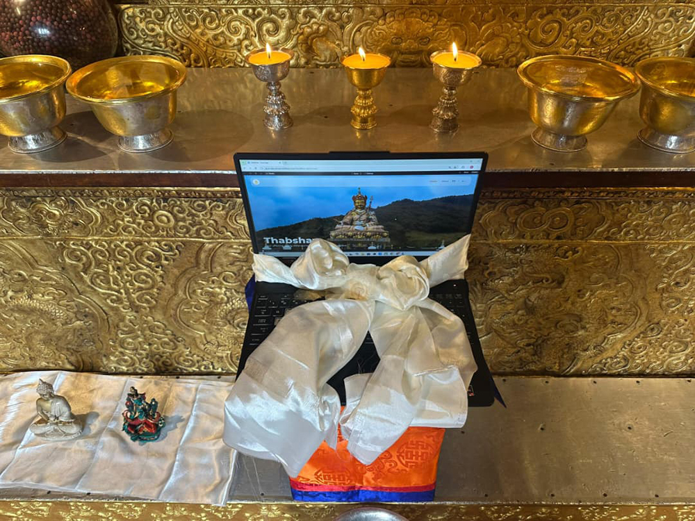 A laptop with a dhar placed on it for the blessing of the Guru App website.