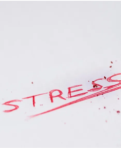 Słowo "STRESS" napisane czerwonym mazakiem i przekreślone na białym tle, ilustrujące radzenie sobie ze stresem w terapii w Centrum Terapii i Rozwoju.