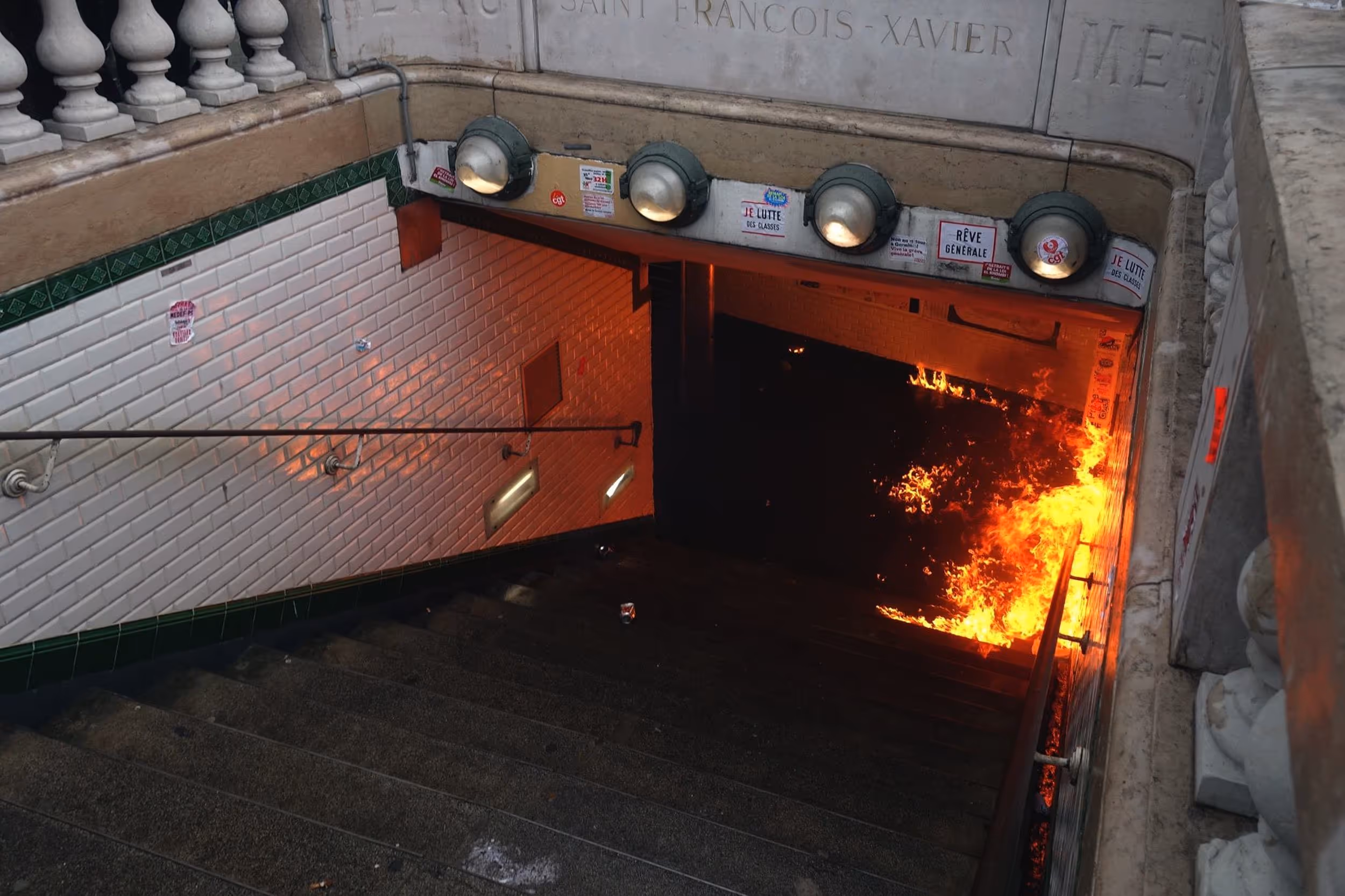 Entrée de la station de métro Saint-François-Xavier en flammes, vue depuis le haut de l’escalier.