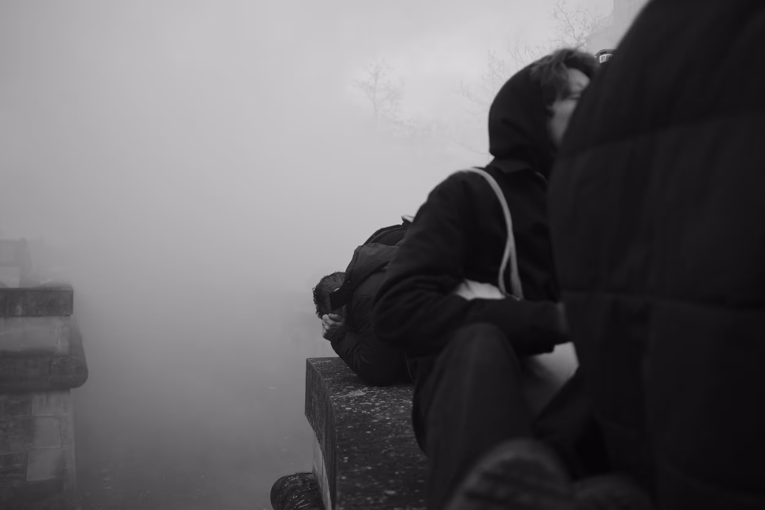 Personnes cherchant refuge ou couvrant leurs visages au milieu d’un épais nuage de fumée.