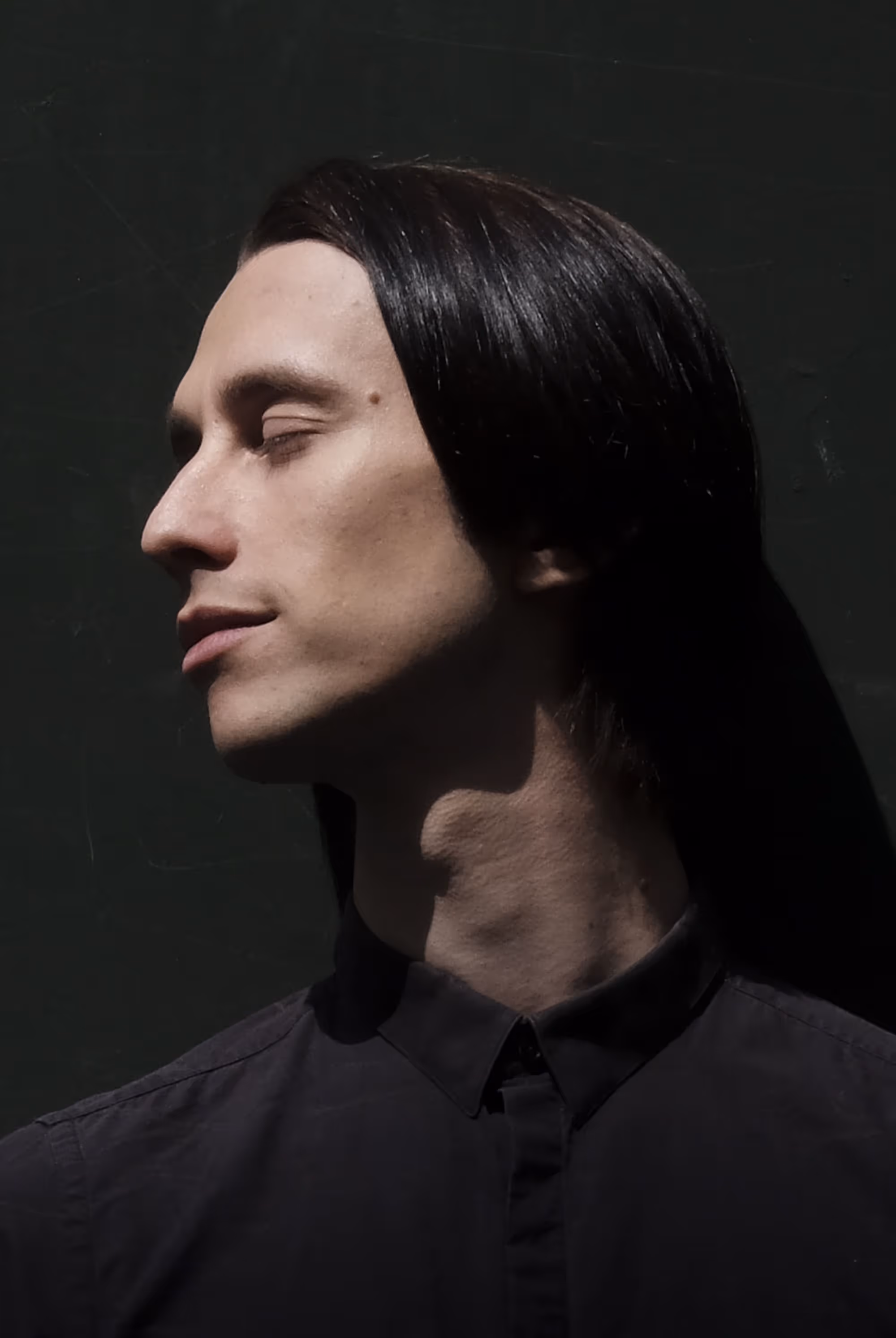 Portrait d’un homme de profil, yeux fermés, baigné d’une lumière latérale qui accentue la texture de la peau.