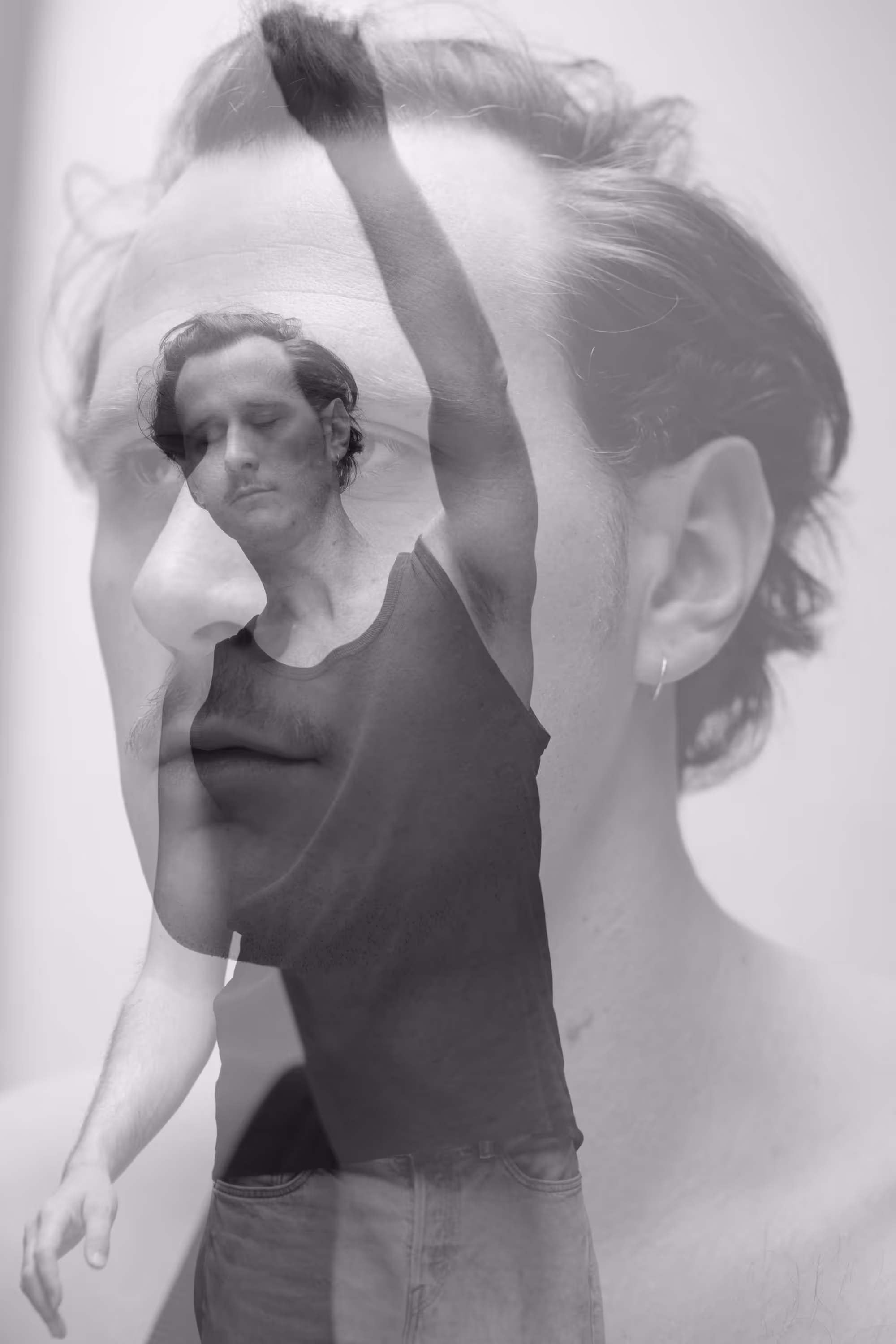 Double exposition d’un homme en mouvement bras levé avec son propre visage en arrière-plan.