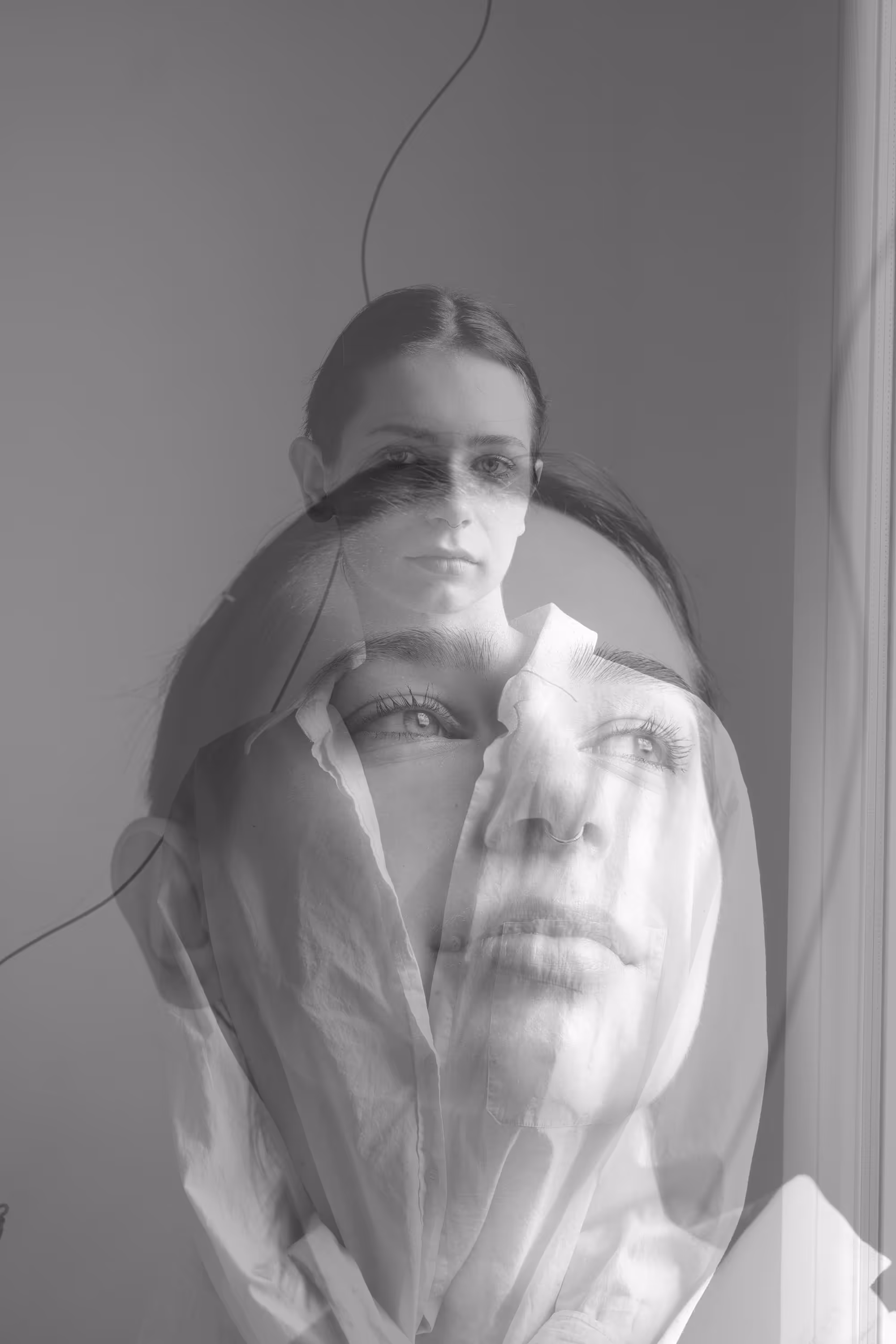 Double exposition d’une femme portant une chemise superposée à son visage couvert d’un tissu blanc.