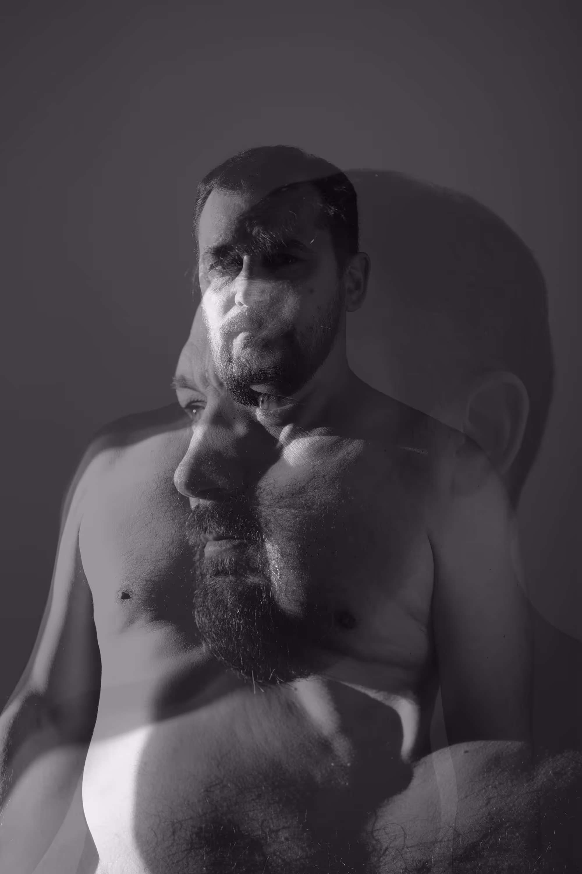Portrait en double exposition d’un homme torse nu avec son profil superposé en jeu d’ombre.