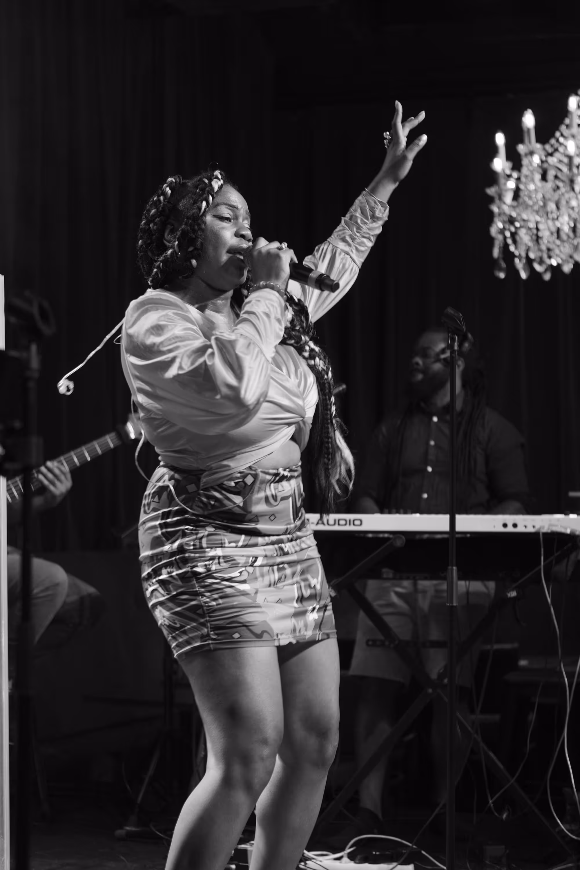 Chanteuse interprétant une chanson sur scène, accompagnée par un claviériste.