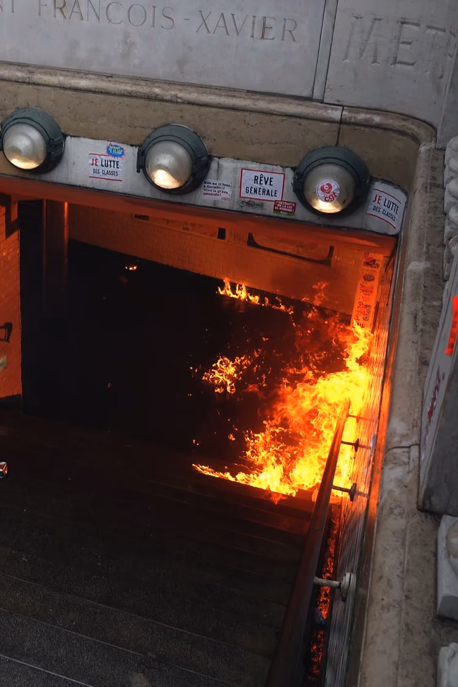Métro François-Xavier avec des flammes vif brûlant les escaliers de la station.