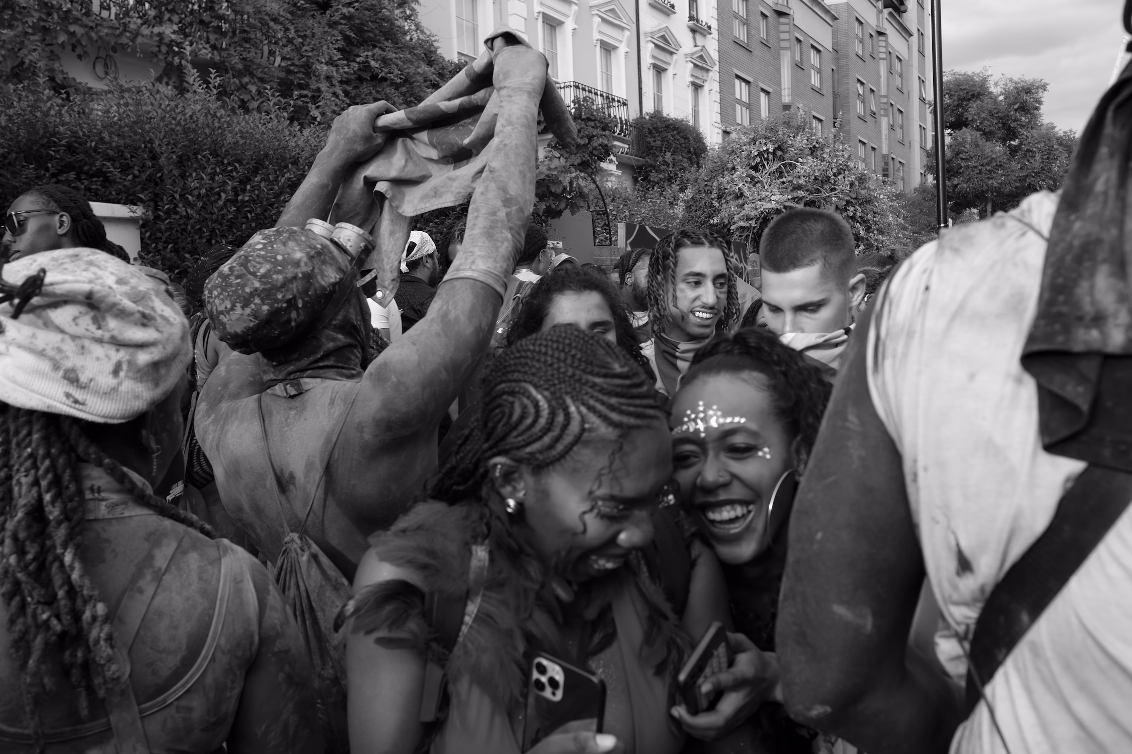 Groupe de jeunes riant et célébrant ensemble la fête du carnal dans la rue.