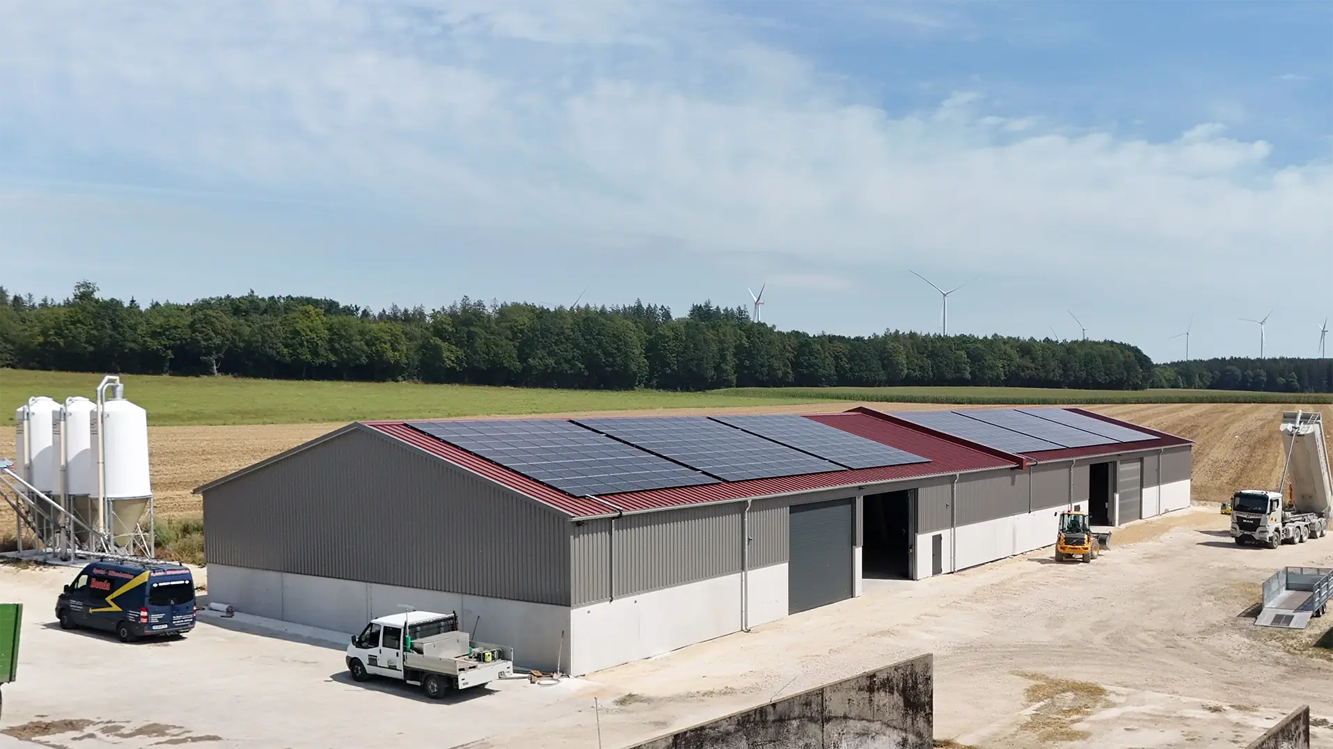 Die fertig sanierte Mehrzweckhalle nach einem Großbrand. Das Gebäude wurde neu gebaut, auf dem roten Dach liegen Solarpaneele. 