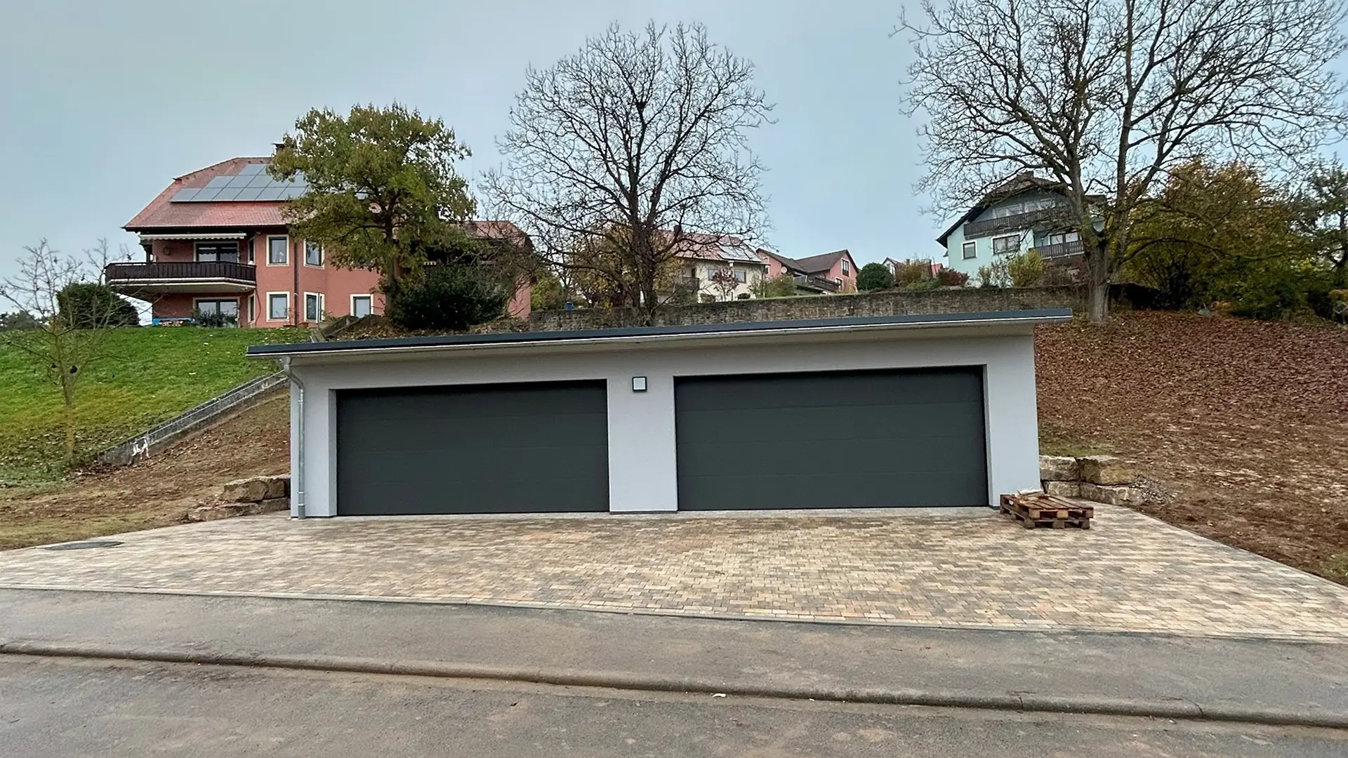 Die fertige Doppelgarage nach der Sanierung. Die Garage wurde mit der Sanierung direkt modernisiert. Das Bild zeigt die Garage in der Frontalansicht mit geschlossenen Toren.