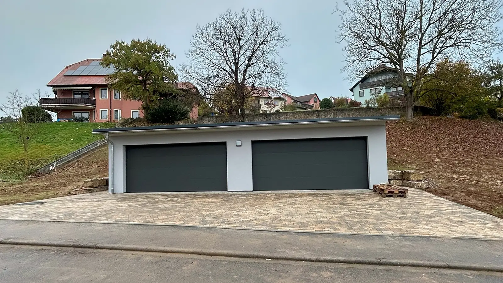 Die fertige Doppelgarage nach der Sanierung. Die Garage wurde mit der Sanierung direkt modernisiert. Das Bild zeigt die Garage in der Frontalansicht mit geschlossenen Toren.