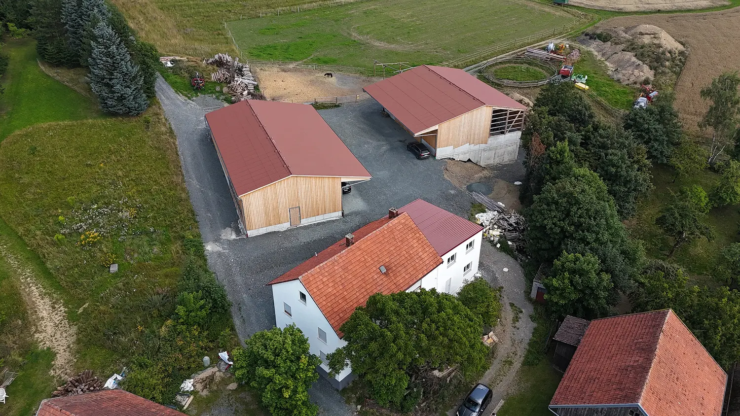 Luftaufnahme des neu aufgebauten Hofareals mit Pferdestall und Lagerhalle