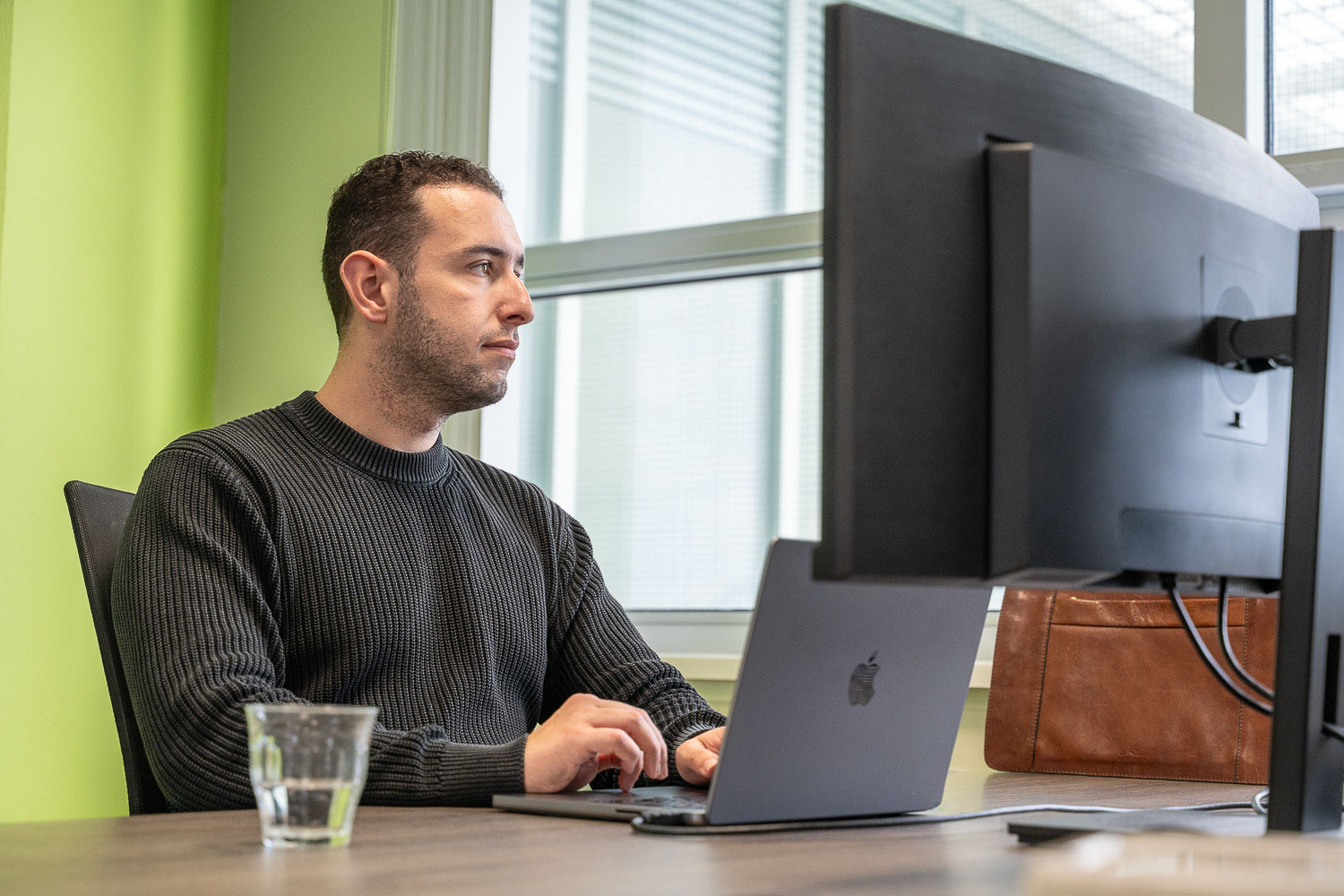 The PuraSec Sales Advisor works at his computer in the office and has a serious look on his face.