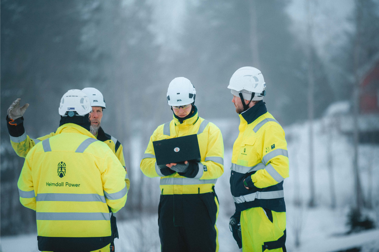 A group of people with security gear discussing on an open field