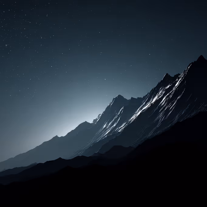 Silhouetted mountain range at night with starlit sky and faint light glowing behind the peaks.