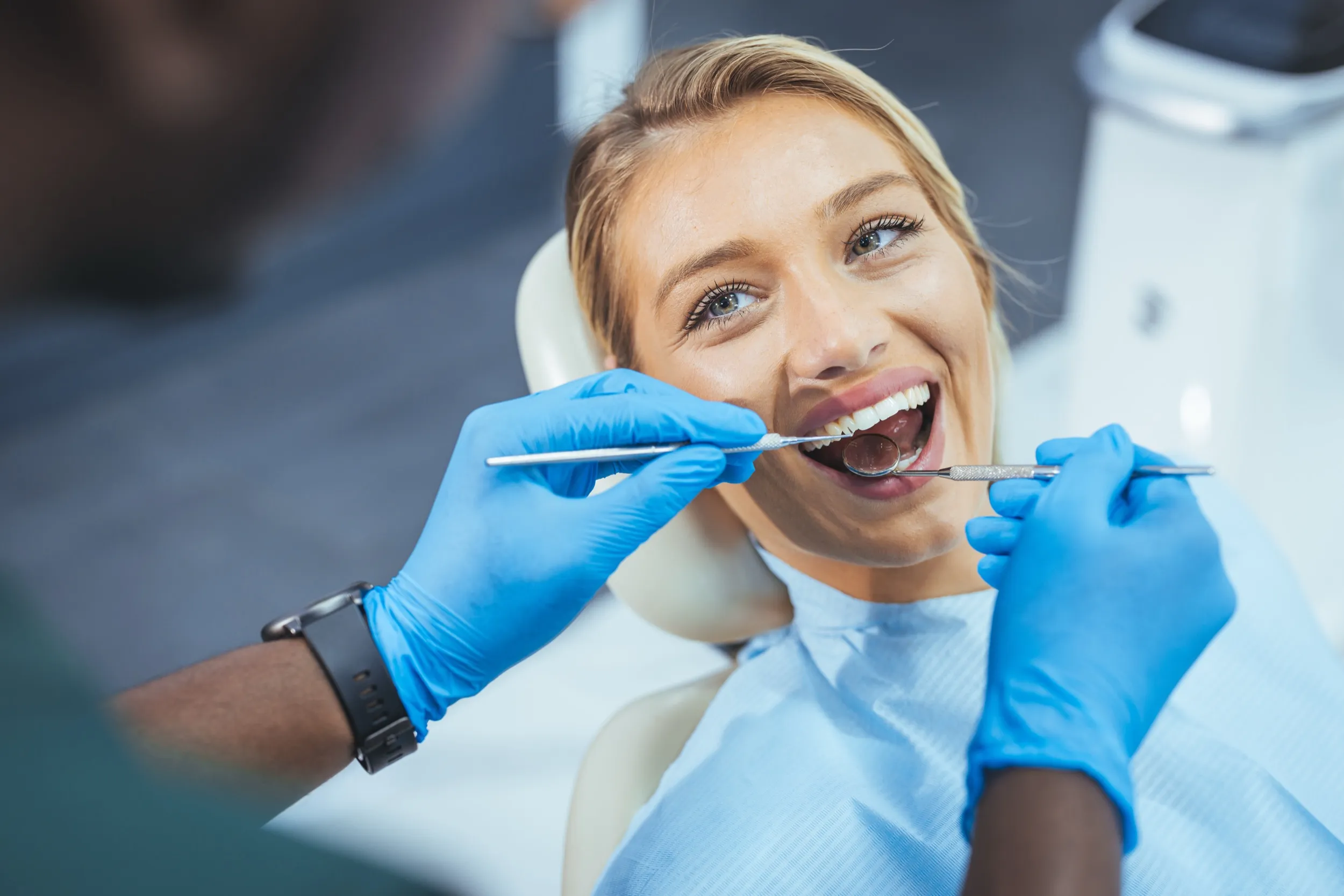 A woman getting her teeth checked by a dentist