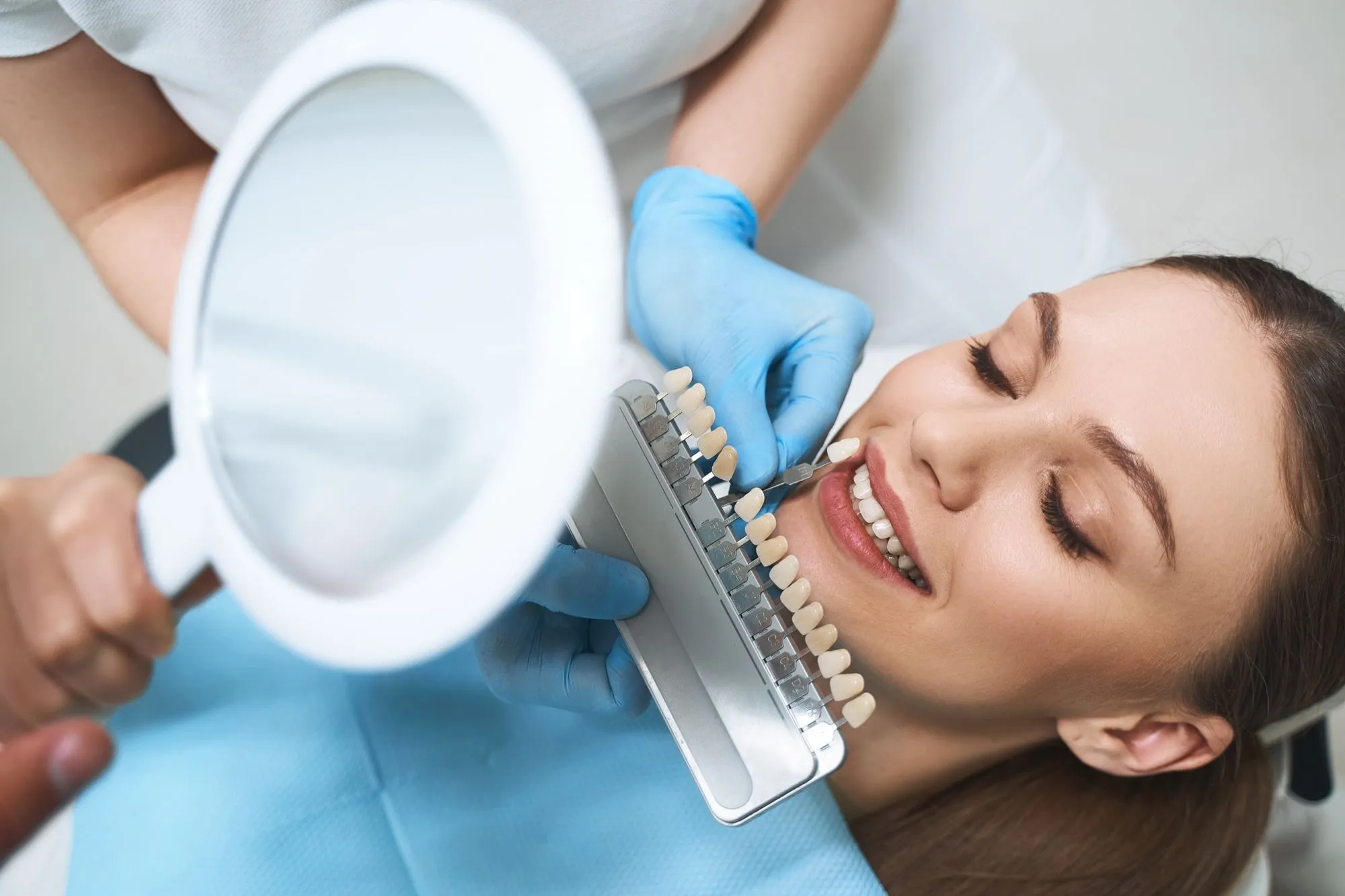 A woman getting her teeth brushed by a dentist