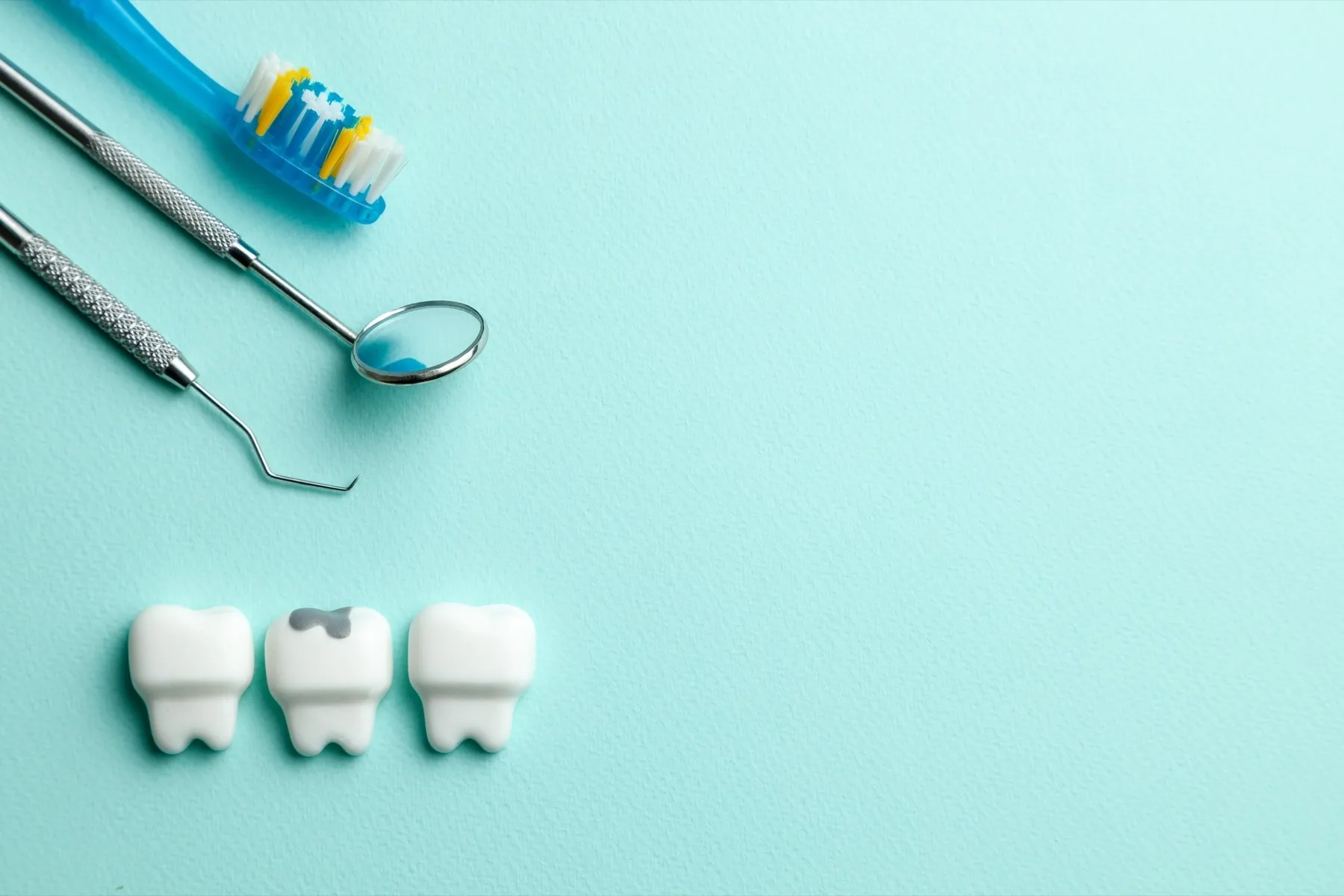 A toothbrush, dental floss, and dental floss on a blue background