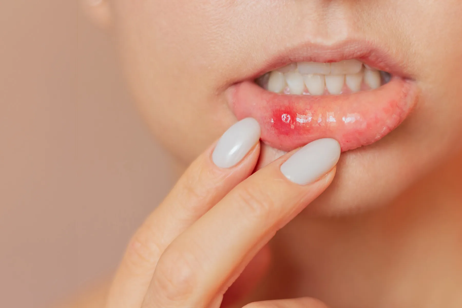A woman holding a piece of food in her mouth