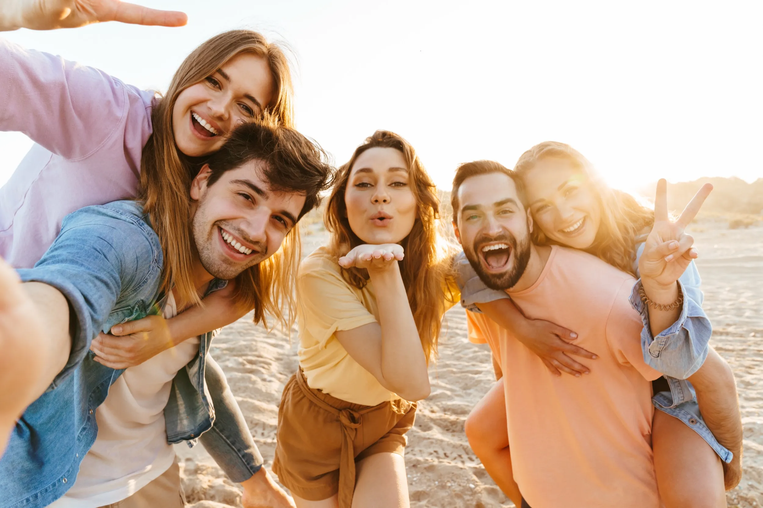 Friends laughing and having fun together on a sunny beach
