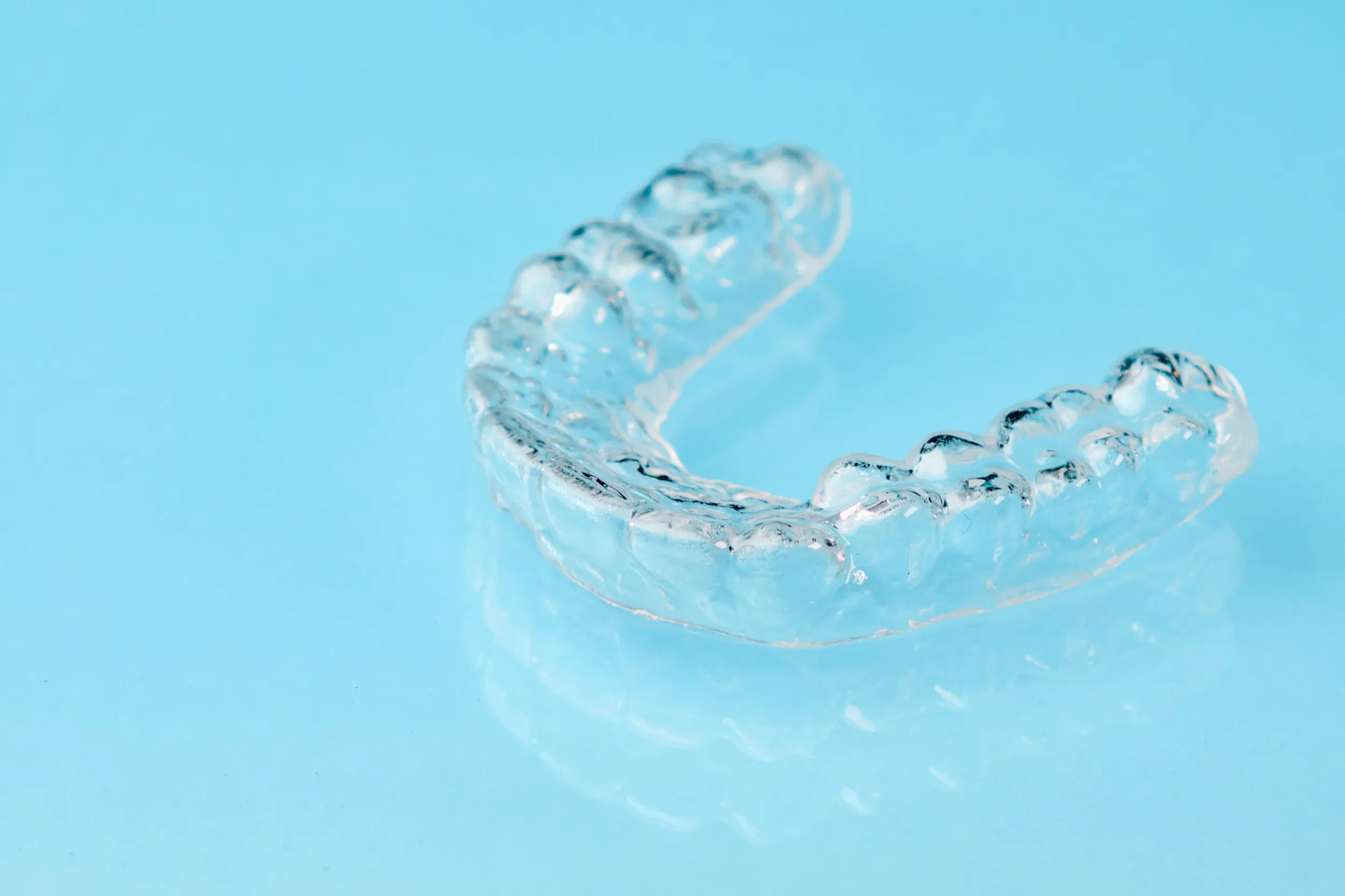 Transparent dental aligners on blue background