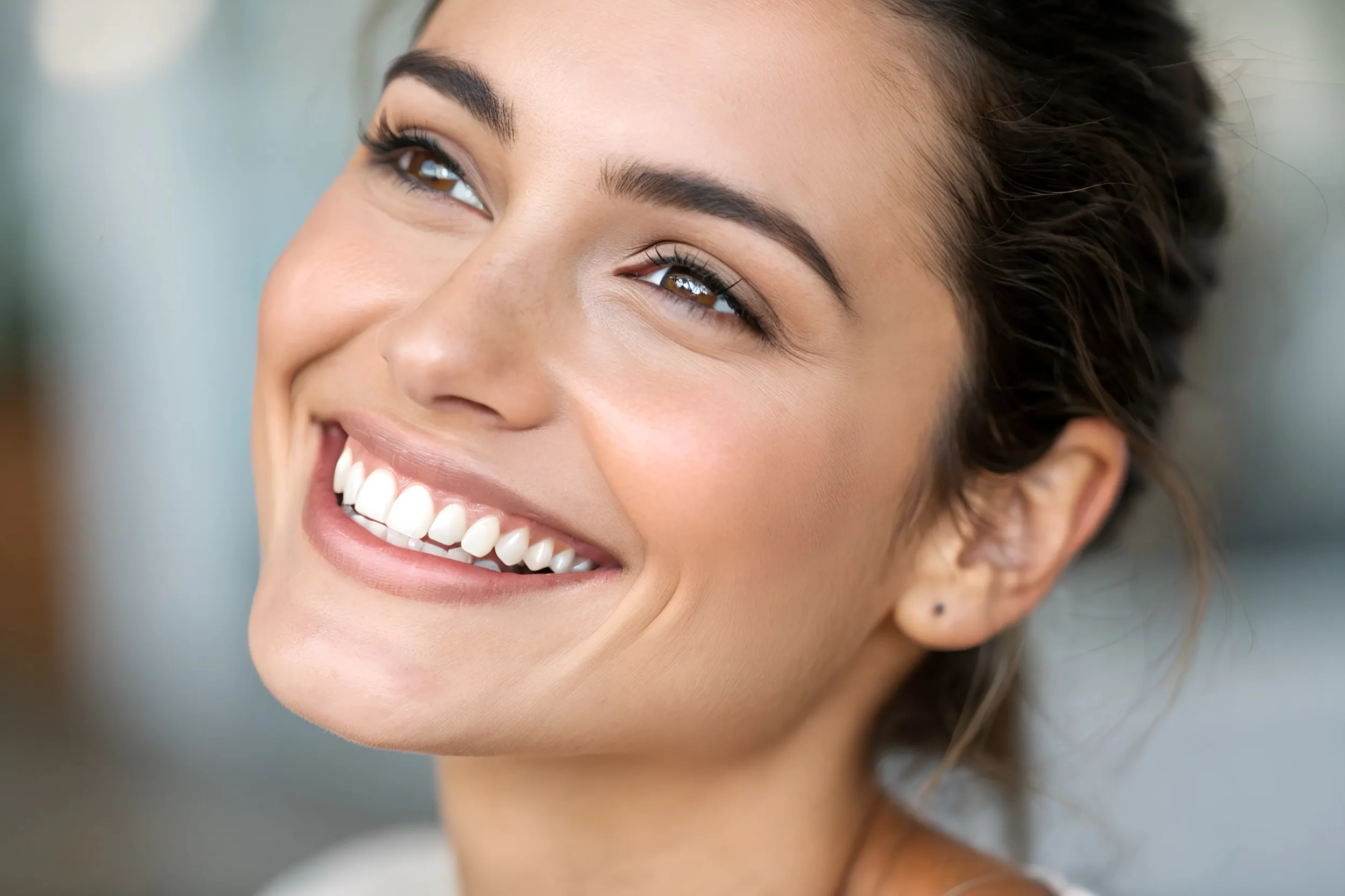 Woman with bright smile looking to the side with soft background
