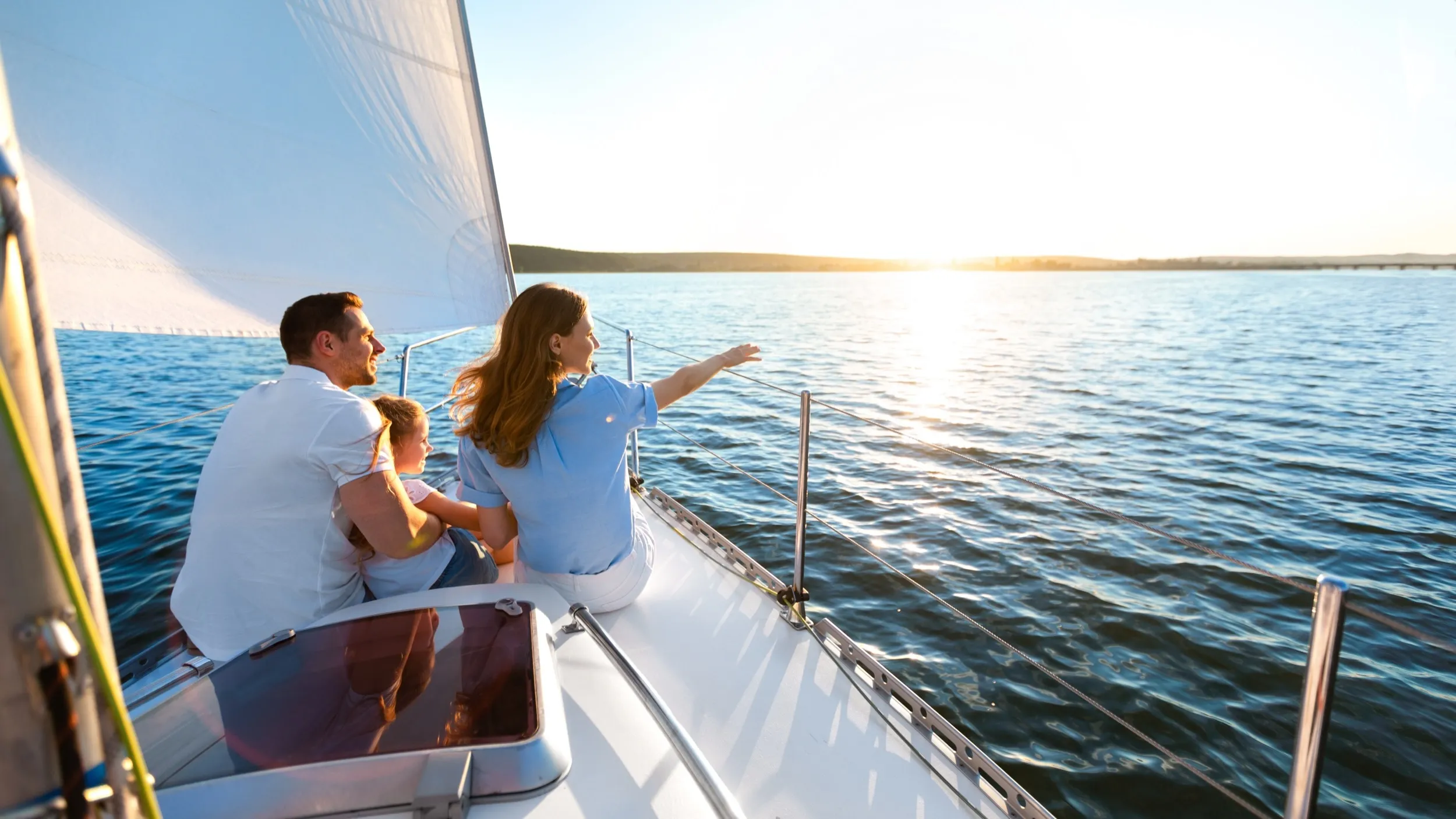 Family sailing together on sunny day, enjoying ocean views and beautiful horizon