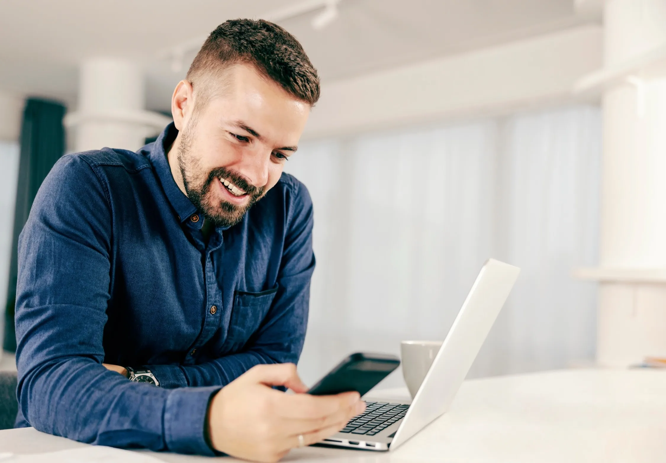 Smiling professional working on laptop in bright, modern office