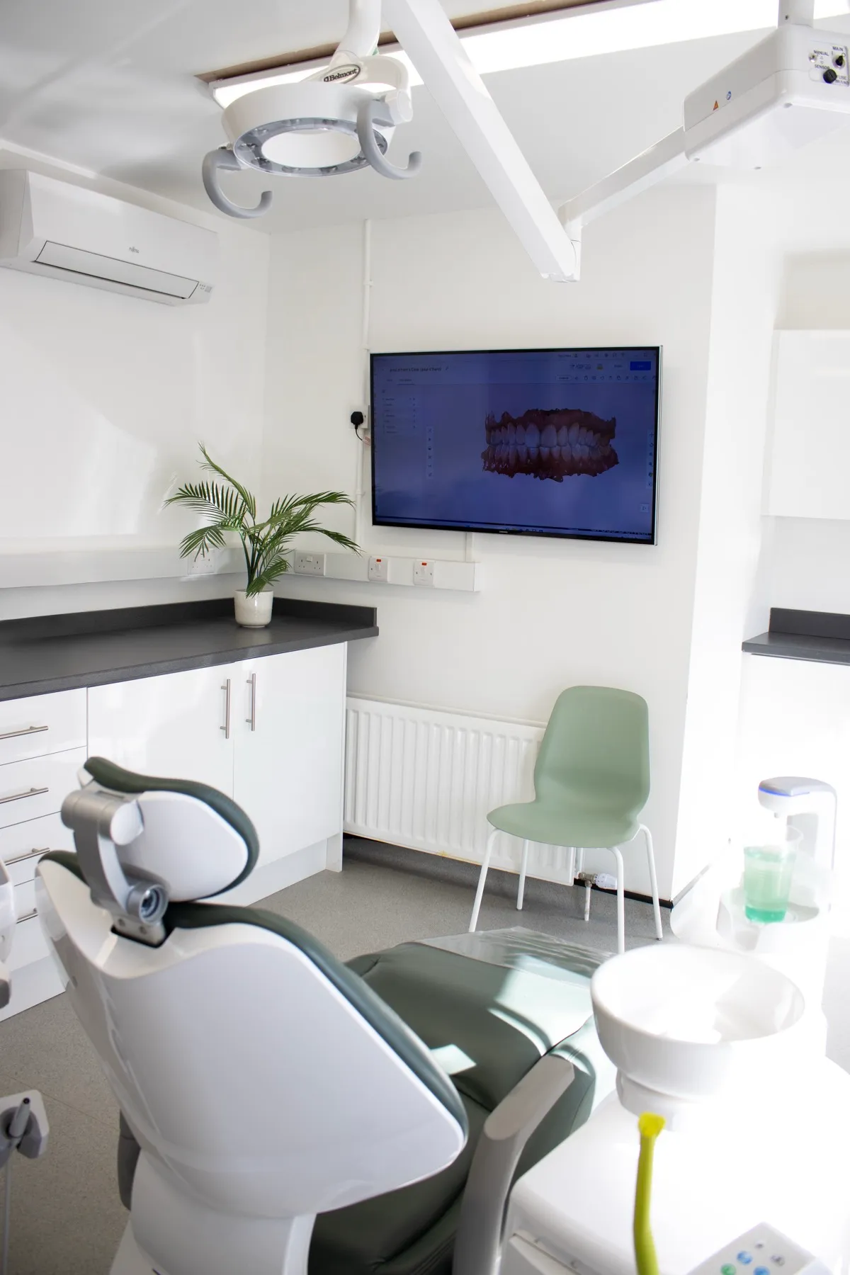 Modern dental office with chair, x-ray screen, and green plant