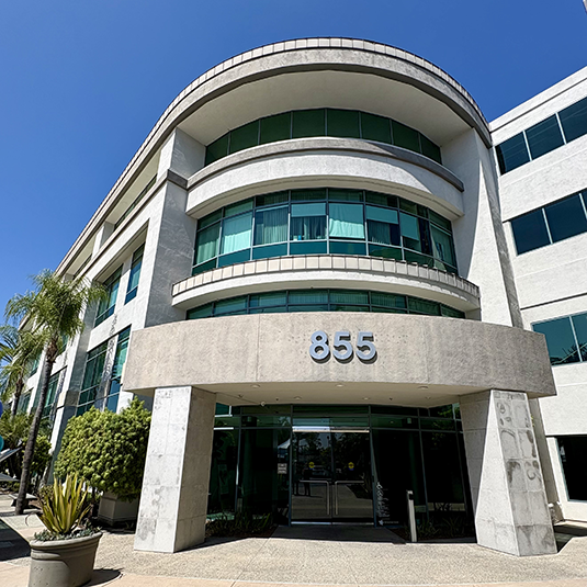 Exterior of the Chula Vista office building at 855 Third Avenue, with curved modern architecture and palm tree landscaping.
