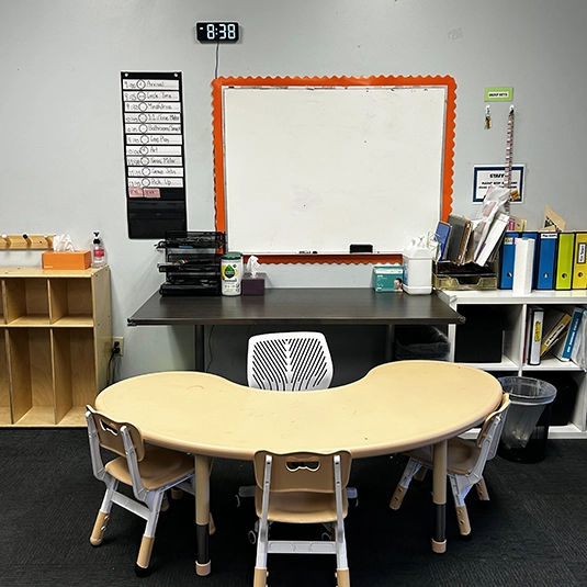 Workstation with whiteboard, kidney table, visual schedule
Structured learning station with a child-sized kidney table, visual schedule, and whiteboard for one-on-one ABA sessions.
