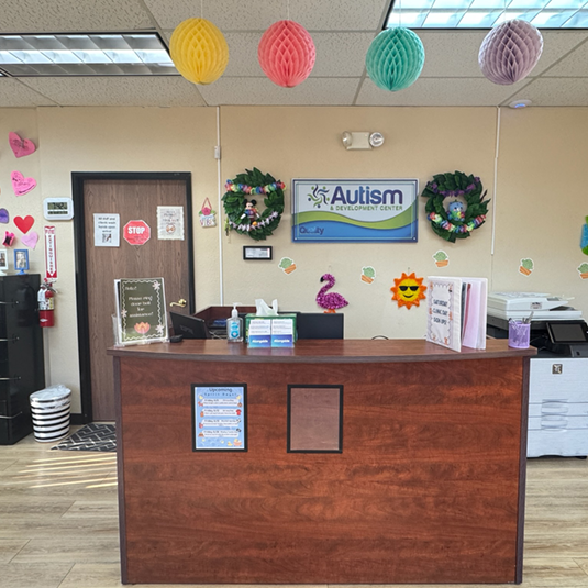 Front reception desk at the Lancaster clinic with a welcome counter, seasonal decorations, and paper lanterns overhead.