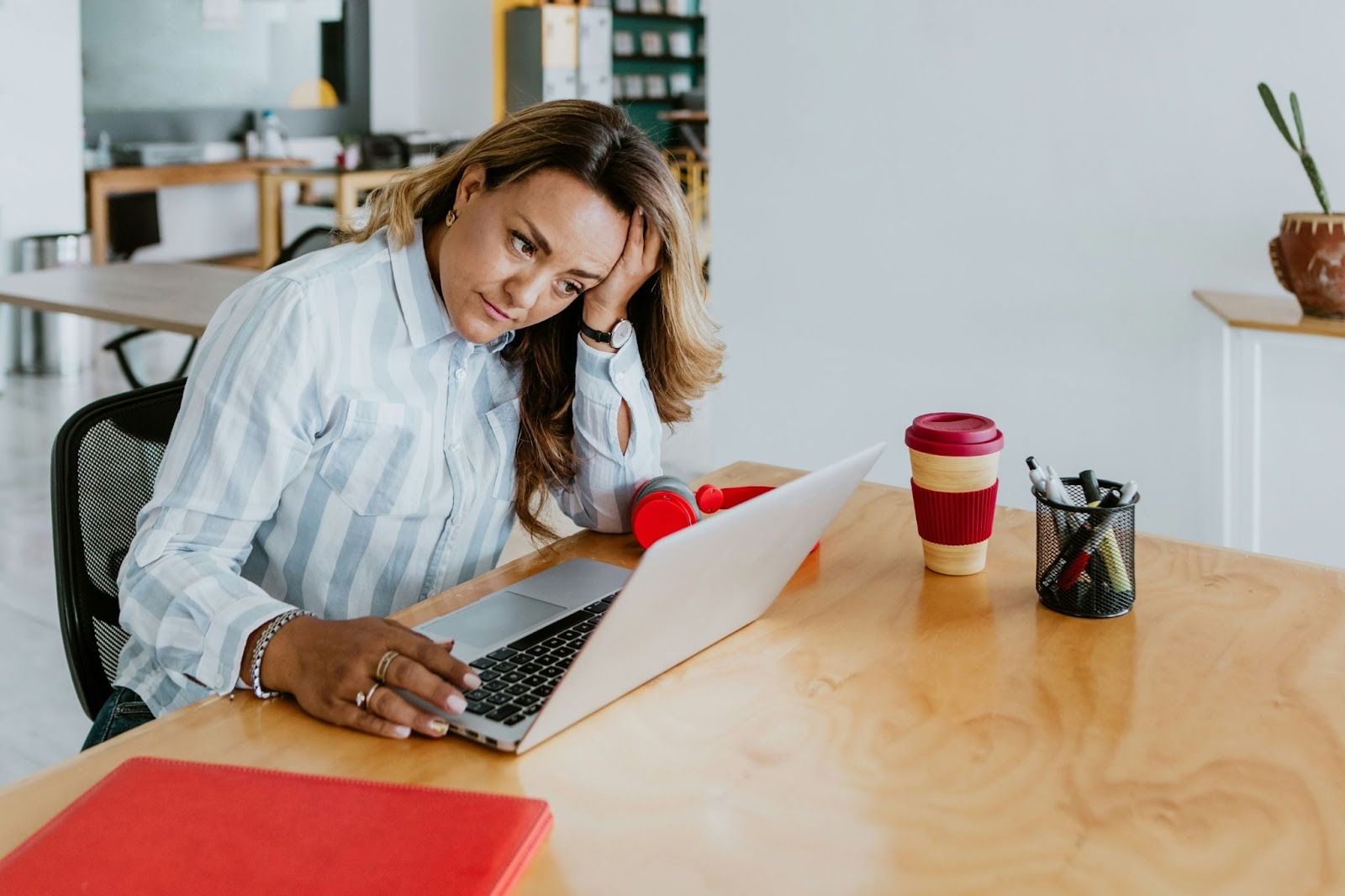 Professional looking frustrated at her laptop while managing repetitive administrative tasks