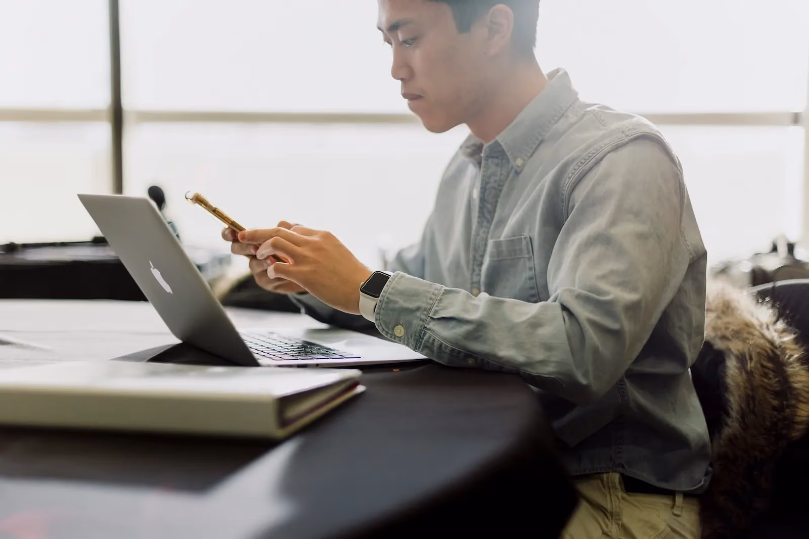 Business professional reviewing information across laptop and phone, illustrating registered agent compliance risks and missed legal notices