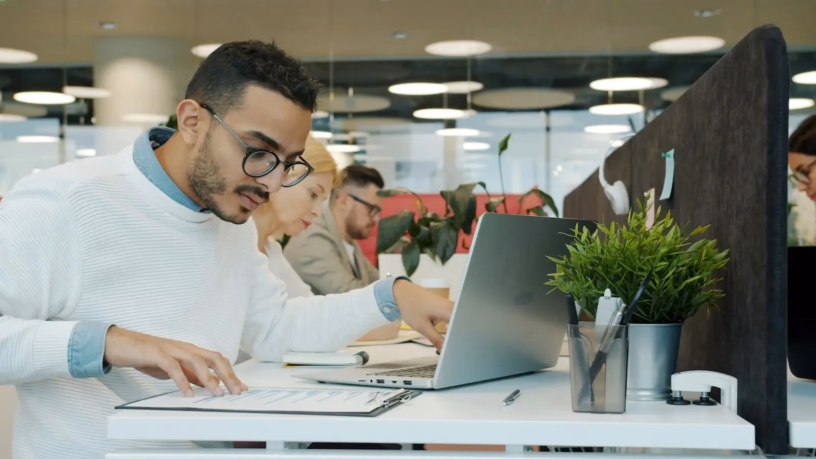 Small business professional reviewing compliance checklist documents at a modern office desk