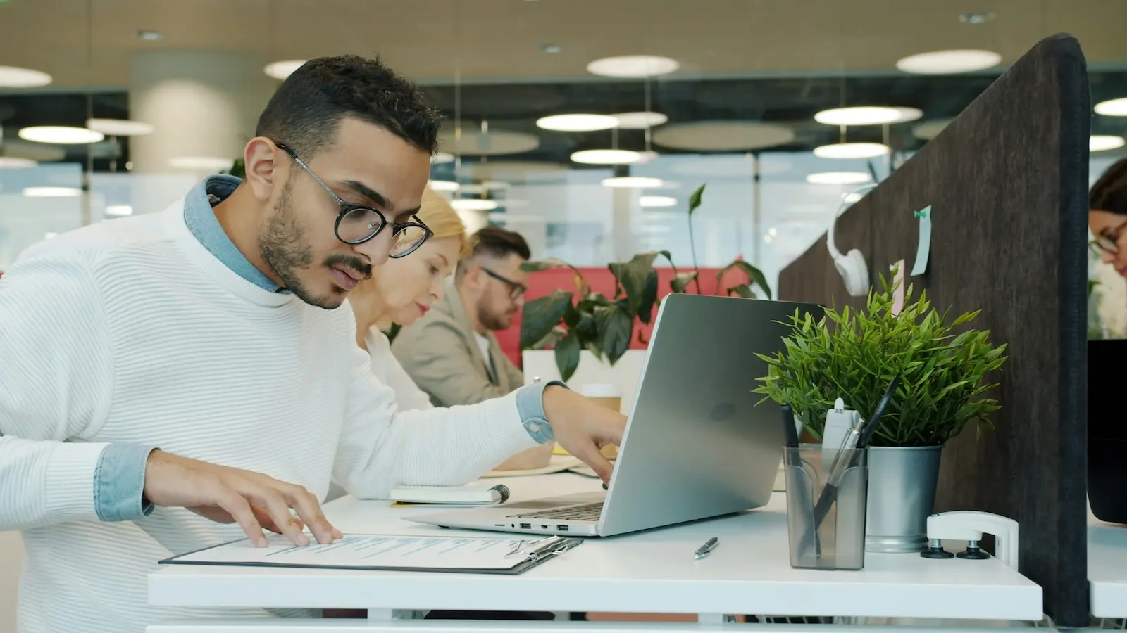 Small business professional reviewing compliance checklist documents at a modern office desk