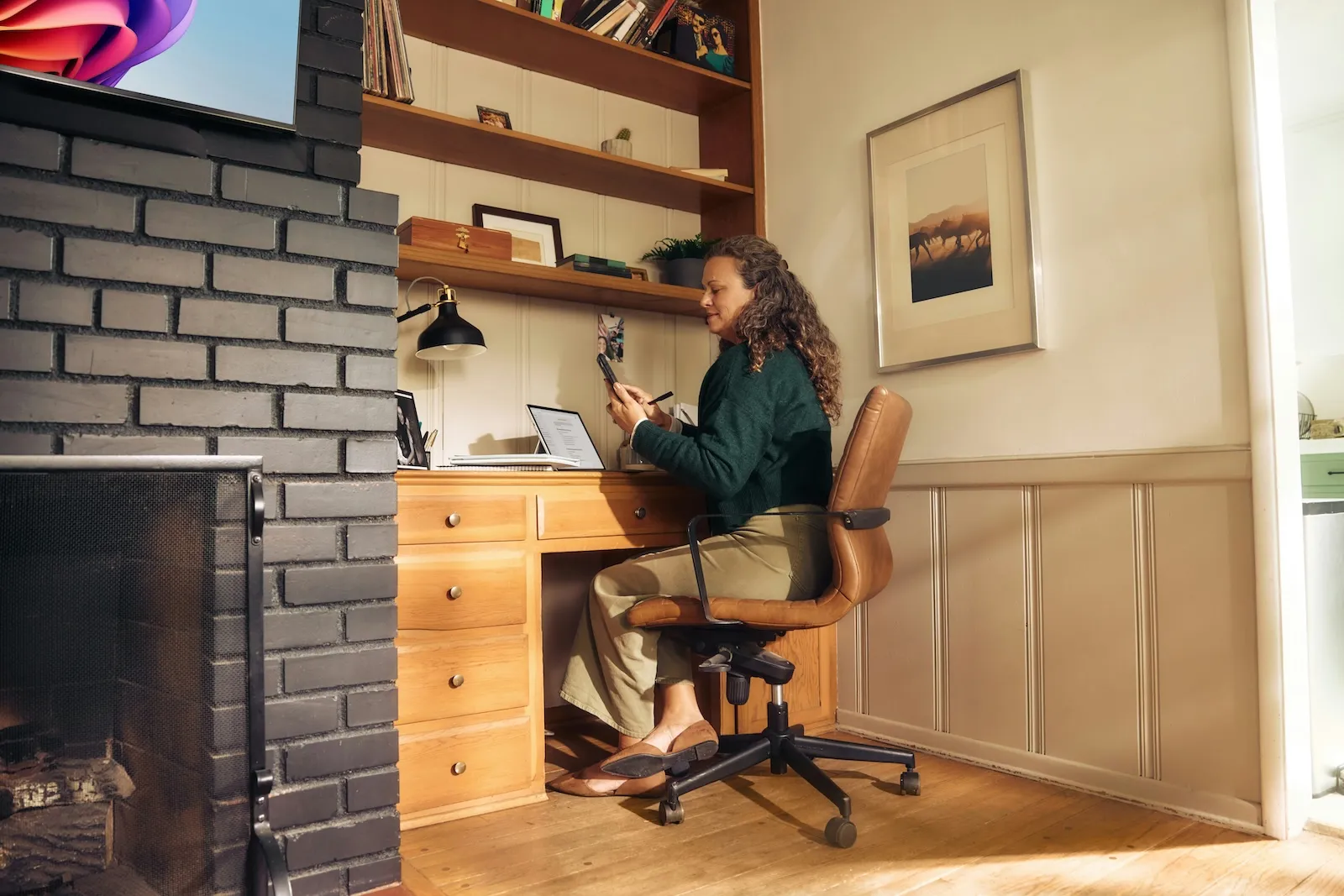 Professional working from a home office using a phone and laptop, showing how digital mail solutions enable remote business operations